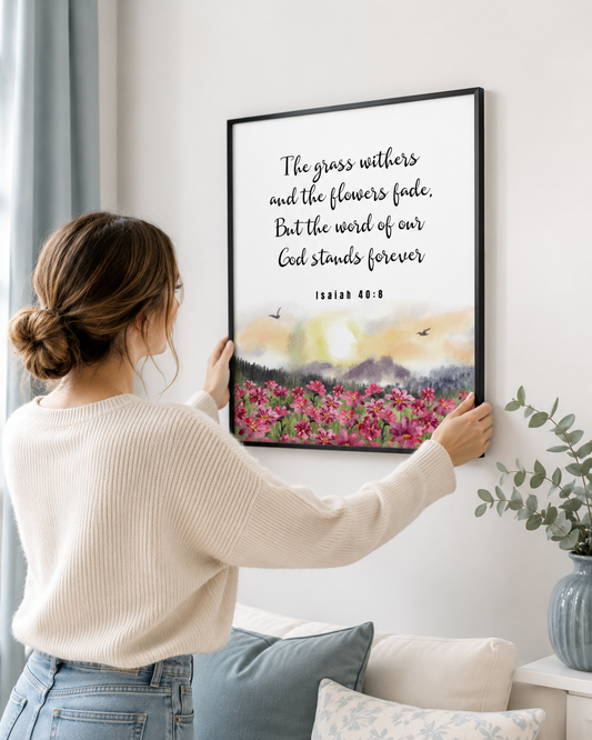 Woman hanging a framed Isaiah 40:8 print on a wall