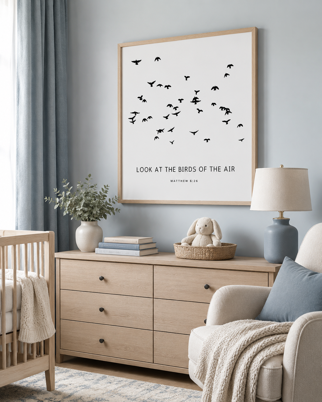 Minimalist Bible verse print with black bird silhouettes and the text "Look at the Birds of the Air — Matthew 6:26" in a wood frame above a light oak nursery dresser.

