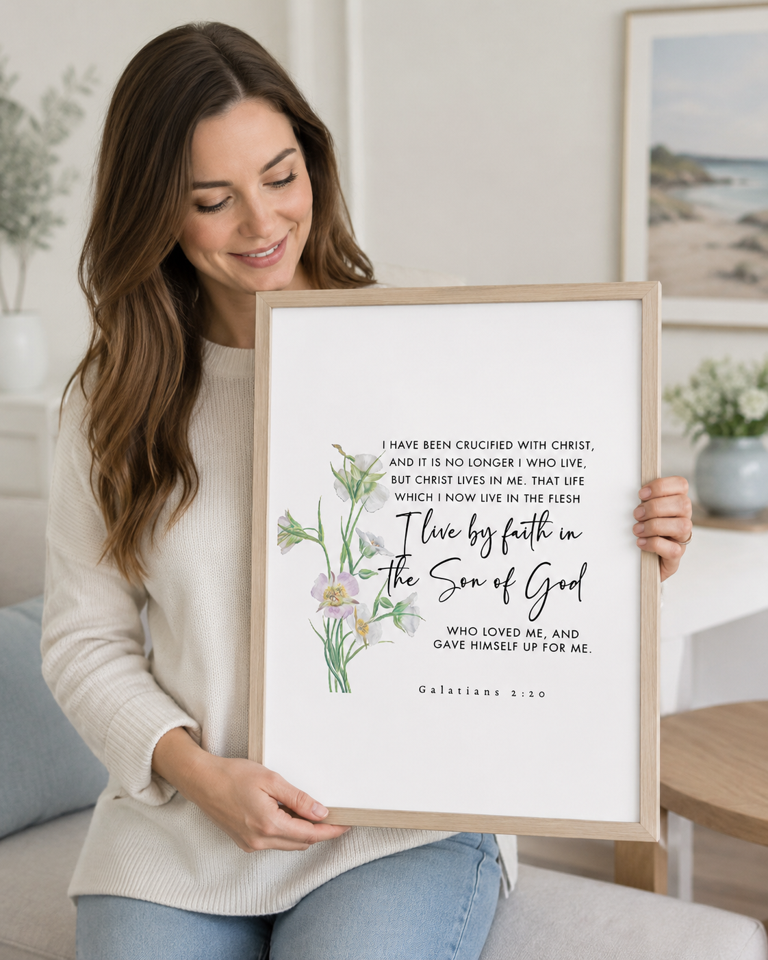 Woman holding a framed Galatians 2:20 Bible verse print at home