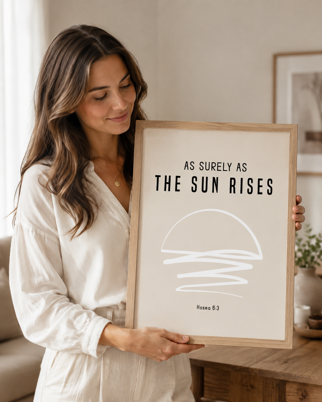 Woman holding a framed Hosea 6:3 Bible verse print at home
