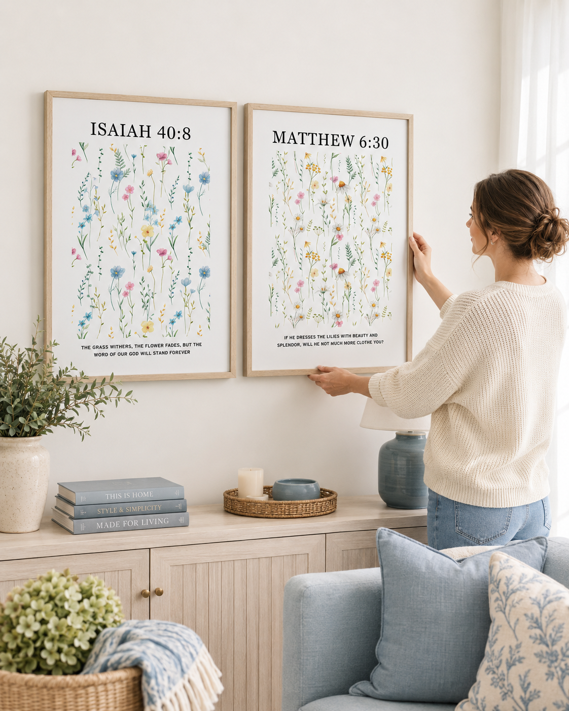 Woman hanging the Isaiah 40:8 and Matthew 6:30 wall art print set on a wall