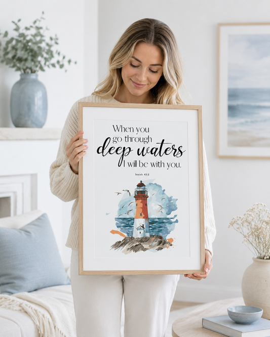 Woman holding a framed Isaiah 43:2 lighthouse Bible verse print at home