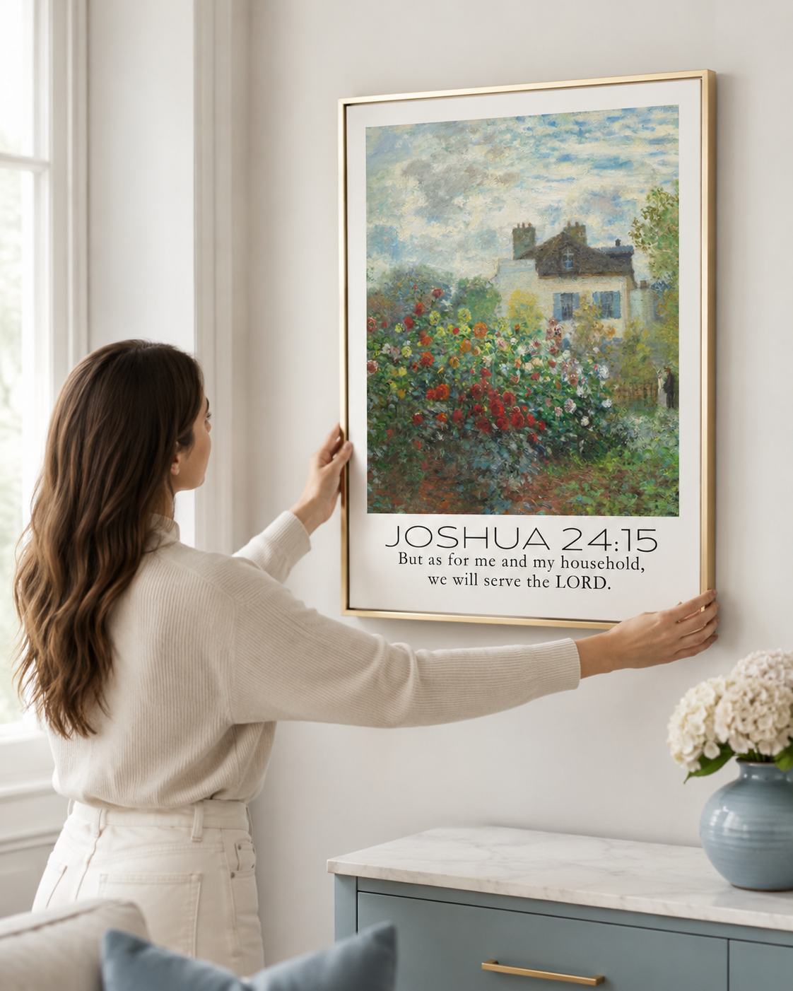 Woman hanging a framed Joshua 24:15 "we will serve the Lord" print on a wall