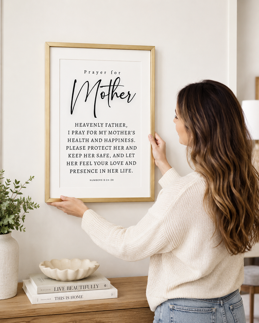Woman hanging a framed Prayer for Mother print on a wall