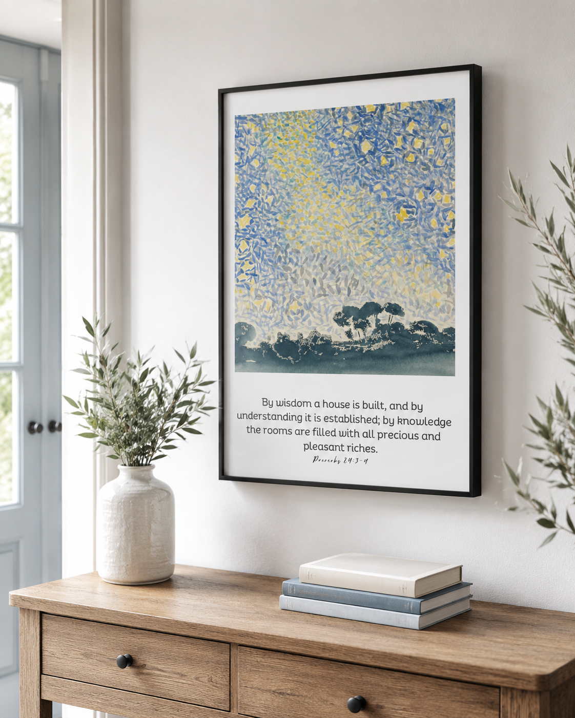 Framed Proverbs 24:3-4 wall art print in a black frame on a console table near an entryway