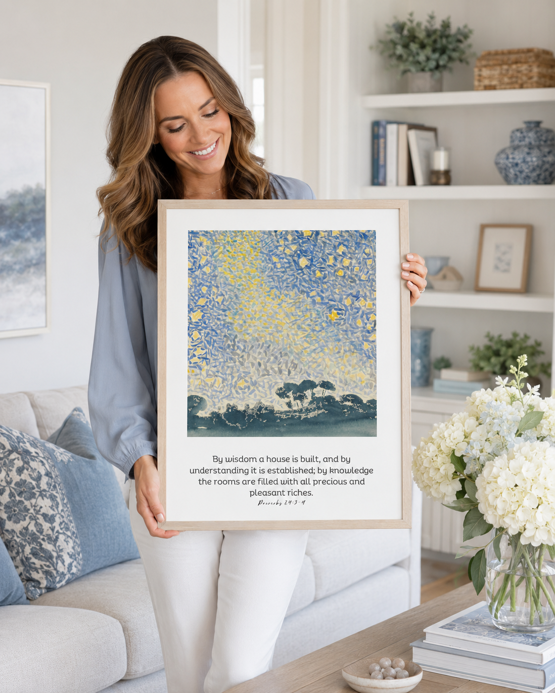 Woman holding a framed Proverbs 24:3-4 Bible verse print at home