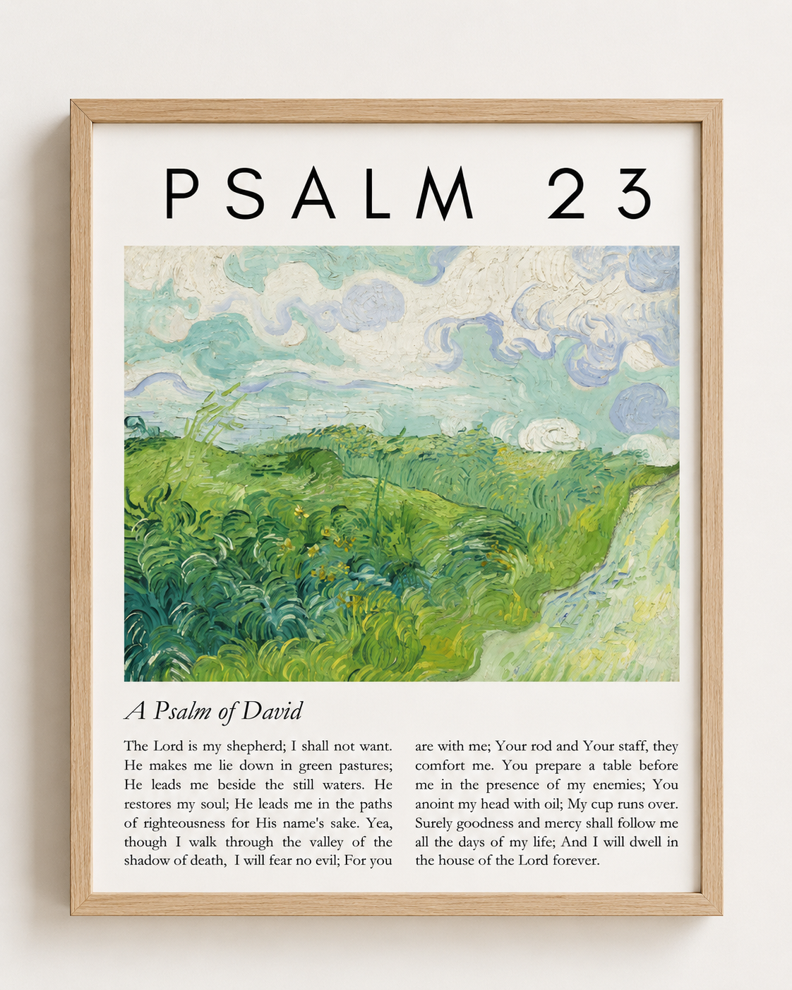 Psalm 23:1-4 wall art print in a wood frame with green pasture illustration, displayed near a blue pillow