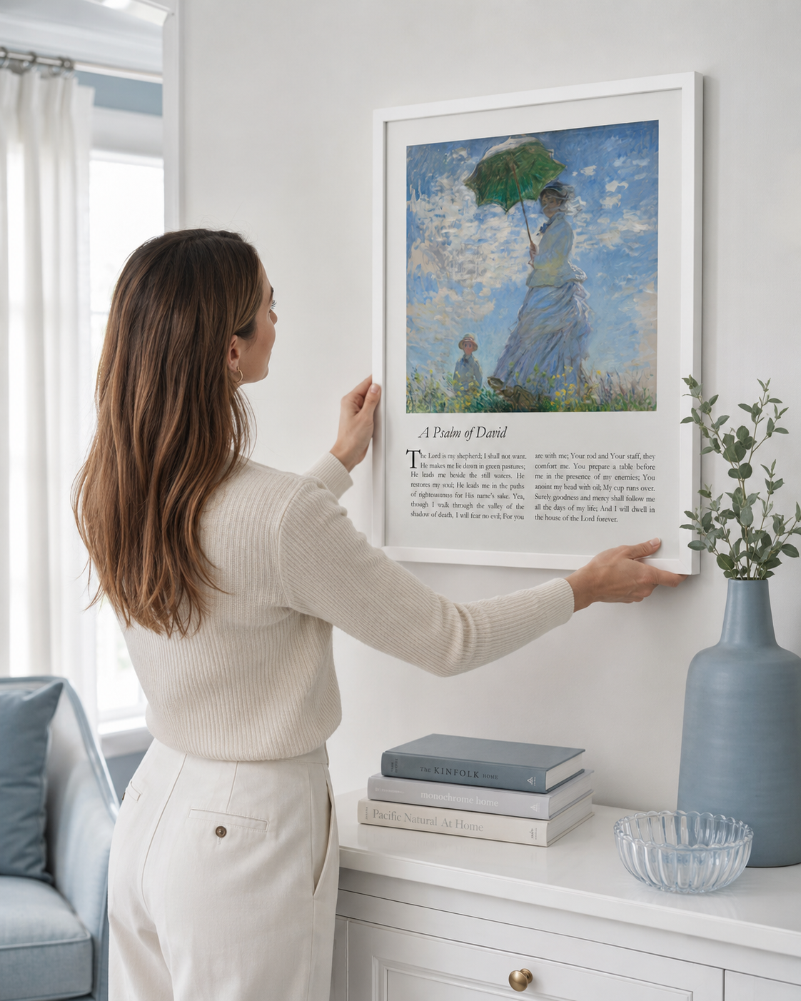 Woman hanging a framed Psalm 23 art print on a wall